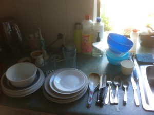 Preparing to wash the dishes: I have already stacked the bowls and plates and sorted the cutlery; the plastics are still as I found them.